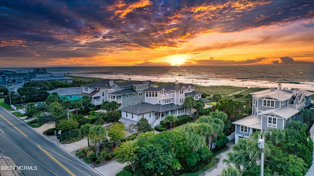 aerial view at dusk featuring a water view