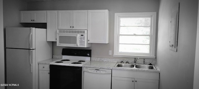 kitchen with white appliances, sink, and white cabinets