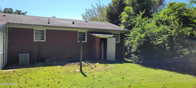 back of house with a yard and central AC