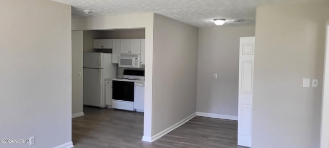 interior space with dark wood-type flooring, white appliances, and a textured ceiling