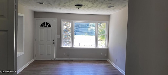 entryway with dark wood-type flooring and a textured ceiling