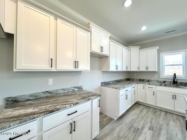 kitchen featuring white cabinetry, sink, and dark stone counters