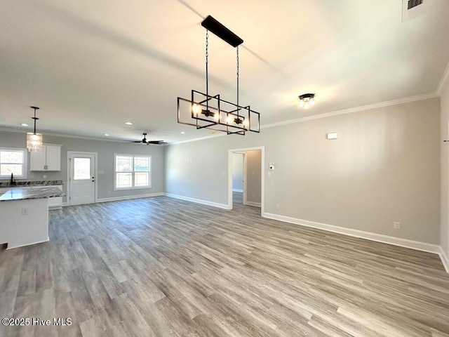 interior space featuring ceiling fan, crown molding, sink, and light wood-type flooring