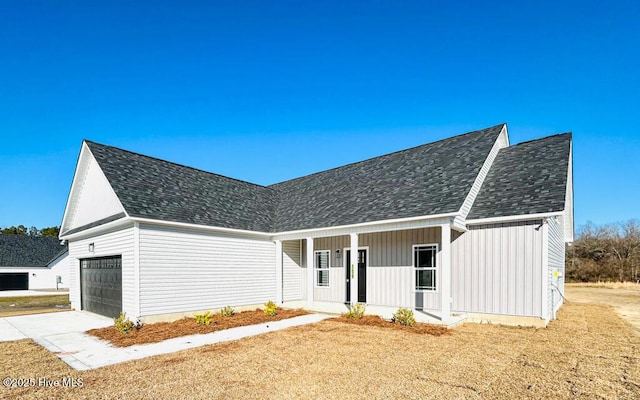 modern inspired farmhouse with a porch and a garage