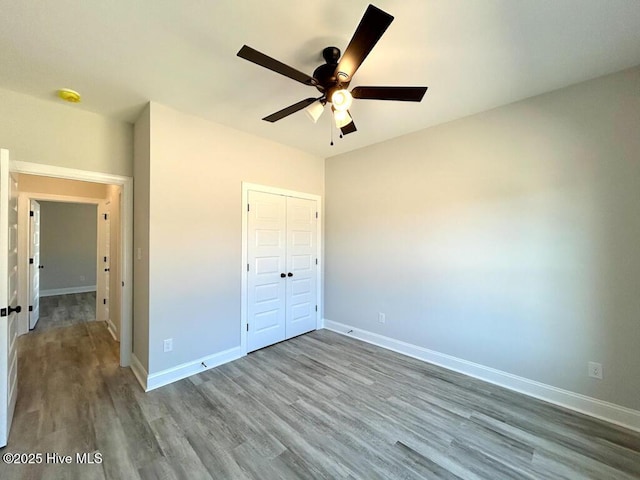 unfurnished bedroom featuring ceiling fan, wood-type flooring, and a closet