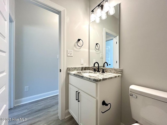 bathroom with hardwood / wood-style flooring, vanity, and toilet