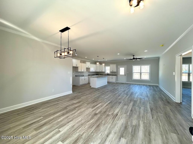 unfurnished living room with ceiling fan, light hardwood / wood-style floors, and crown molding