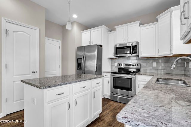 kitchen featuring a kitchen island, pendant lighting, appliances with stainless steel finishes, sink, and white cabinetry