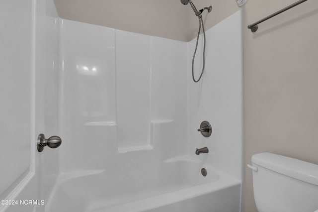 bathroom with washtub / shower combination and toilet