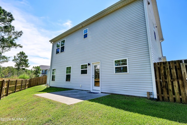 rear view of property with a yard and a patio area