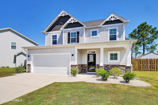 craftsman inspired home with a front lawn, a garage, and covered porch