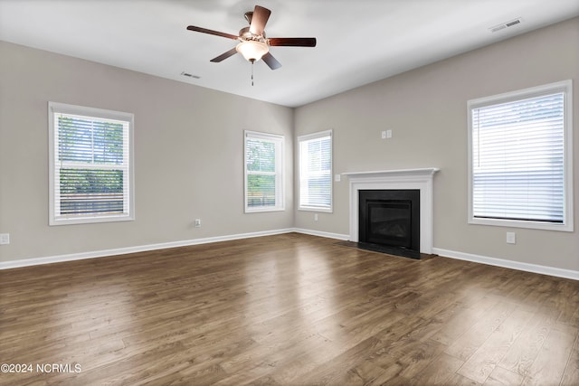 unfurnished living room featuring ceiling fan and dark hardwood / wood-style floors