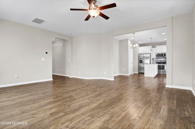 unfurnished living room with ceiling fan with notable chandelier and hardwood / wood-style floors