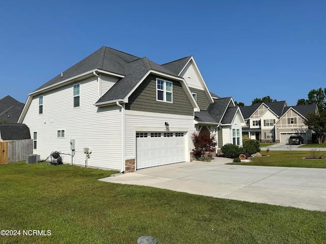 view of front of house featuring central AC unit, a garage, and a front lawn