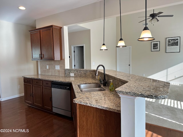 kitchen with sink, stainless steel dishwasher, dark hardwood / wood-style floors, light stone countertops, and decorative light fixtures