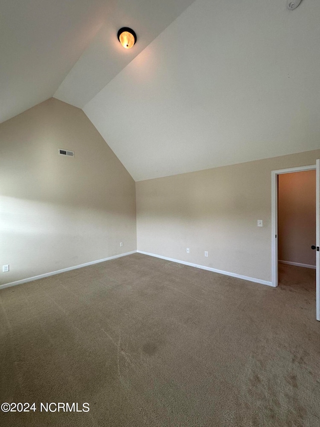 bonus room with carpet floors and vaulted ceiling