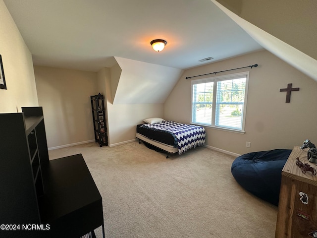 bedroom with light colored carpet and vaulted ceiling