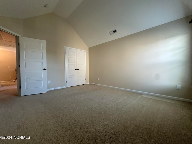 unfurnished bedroom featuring carpet and high vaulted ceiling