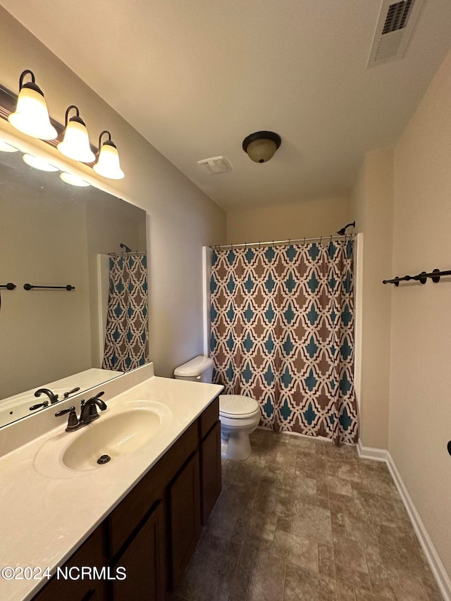 bathroom with vanity, curtained shower, and toilet