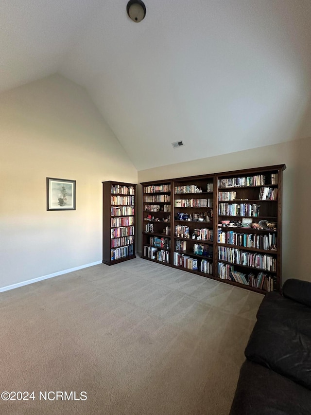 living area featuring carpet and vaulted ceiling