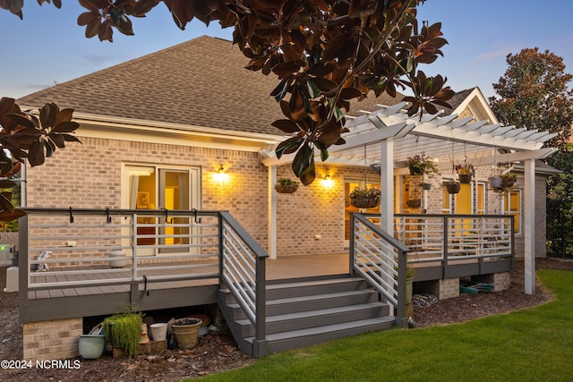 rear view of house with a yard, a pergola, and a deck