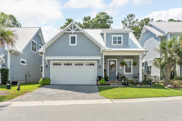 craftsman house with a front yard, covered porch, and a garage