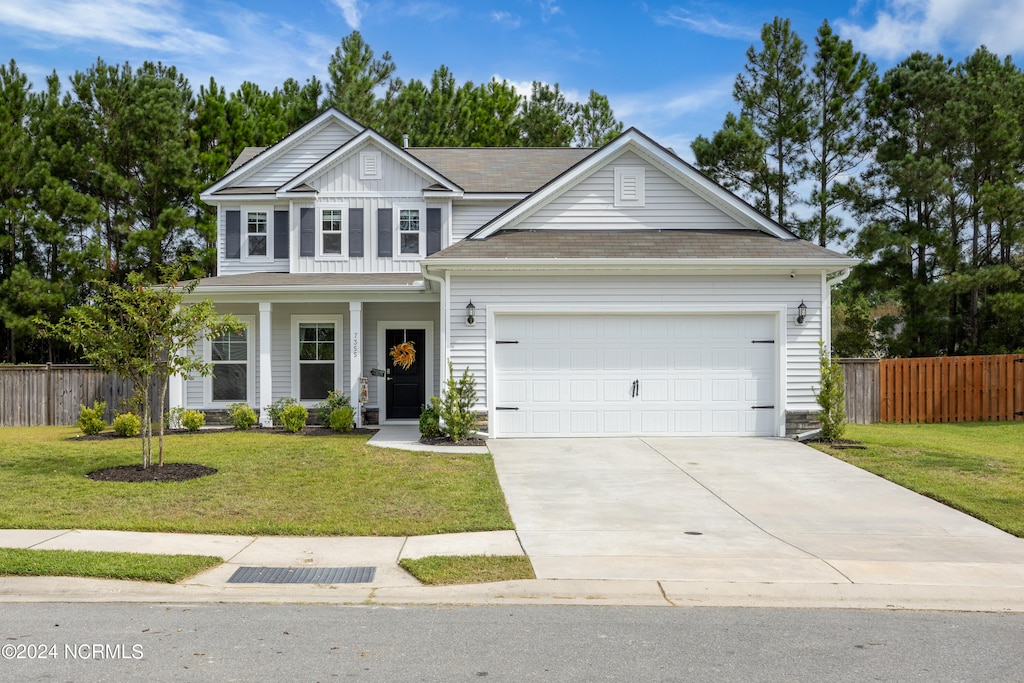 view of front of property with a garage, a front yard, and covered porch