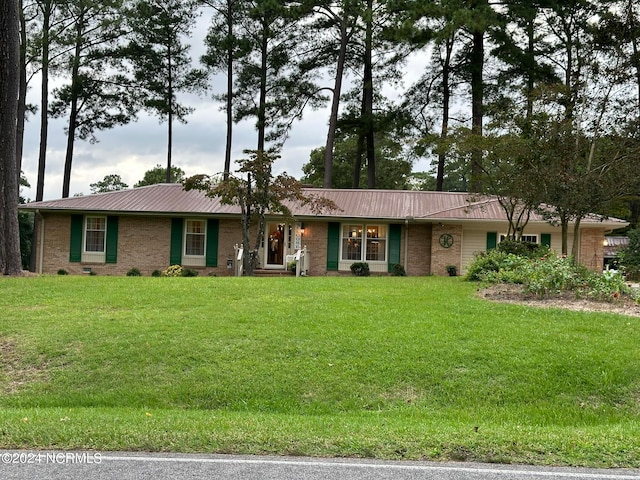 single story home featuring a front lawn