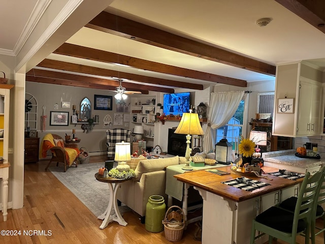 living room featuring ceiling fan, beam ceiling, crown molding, and light hardwood / wood-style floors