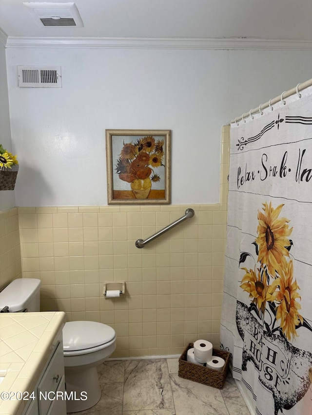 bathroom featuring tile walls, crown molding, vanity, and toilet