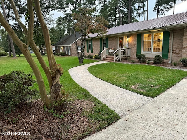 view of front of property featuring a front yard and covered porch