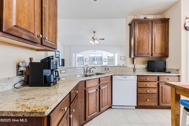 kitchen with ceiling fan, arched walkways, white dishwasher, a sink, and light stone countertops