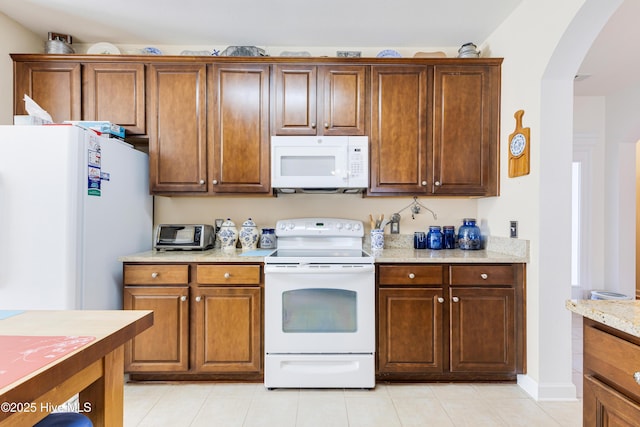 kitchen with white appliances and light stone countertops