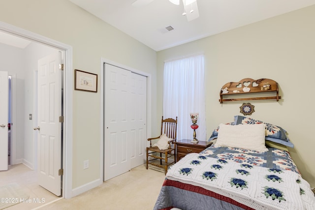 bedroom with ceiling fan, light colored carpet, visible vents, baseboards, and a closet