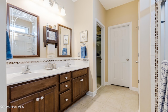 bathroom with double vanity, curtained shower, a sink, and tile patterned floors