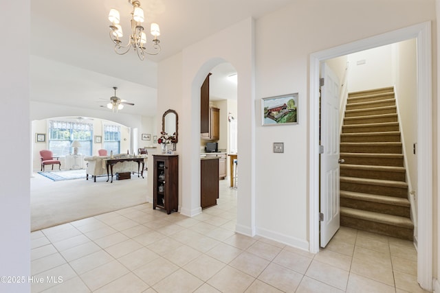 hallway featuring light carpet and a notable chandelier