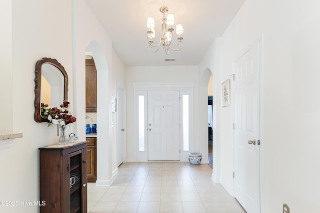 foyer featuring an inviting chandelier and light tile patterned flooring