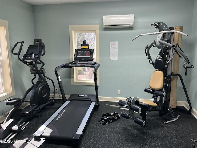 workout room featuring a wall mounted air conditioner, plenty of natural light, and baseboards