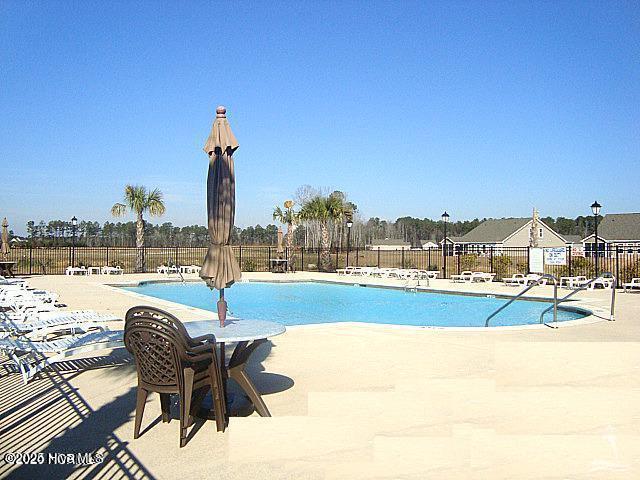 pool featuring a patio area and fence