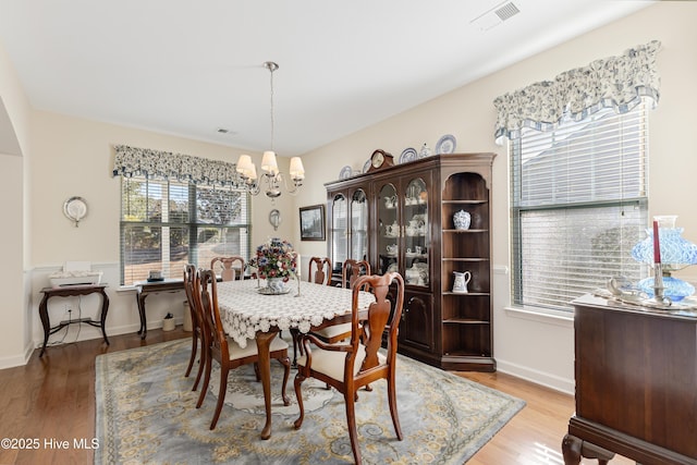 dining area with plenty of natural light, visible vents, and an inviting chandelier