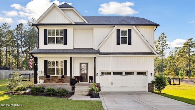 view of front of property featuring a front yard, a garage, and a porch