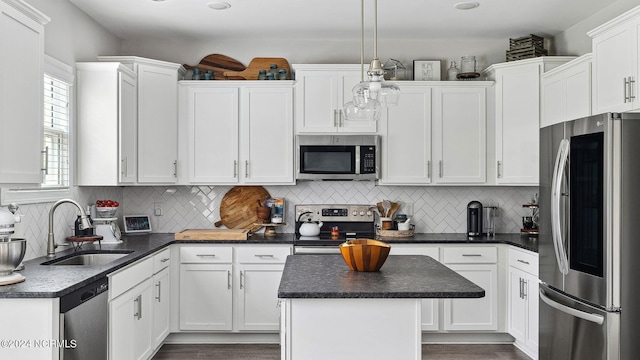 kitchen featuring decorative backsplash, appliances with stainless steel finishes, decorative light fixtures, and sink