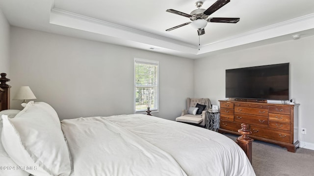 bedroom featuring ornamental molding, a tray ceiling, ceiling fan, and carpet flooring