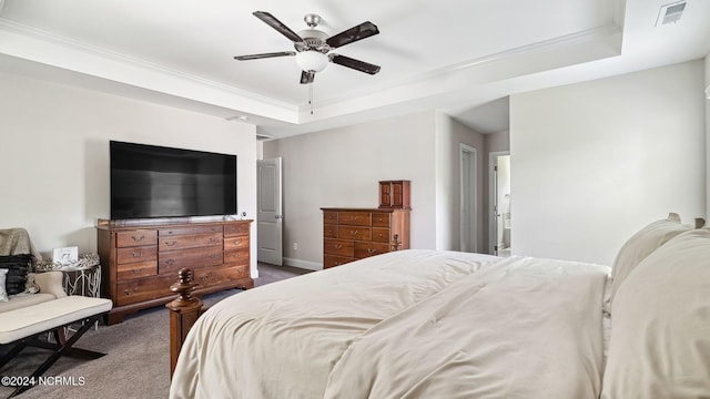 carpeted bedroom featuring a raised ceiling, ornamental molding, and ceiling fan