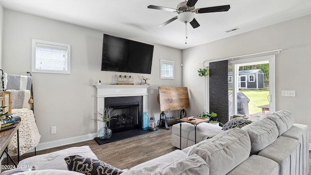 living room with ceiling fan, wood-type flooring, and a healthy amount of sunlight