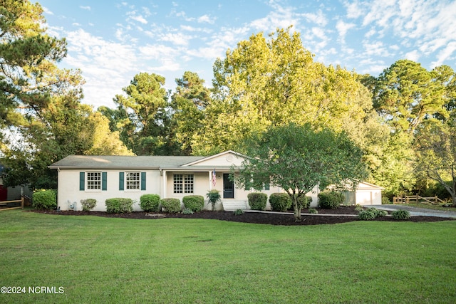 ranch-style home featuring a garage and a front lawn