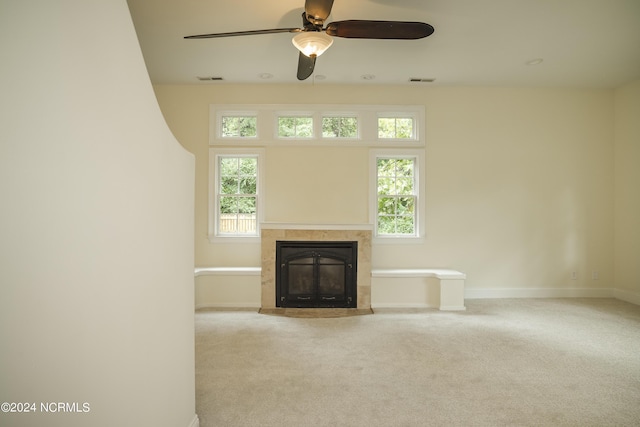 unfurnished living room featuring carpet, a tile fireplace, and a healthy amount of sunlight