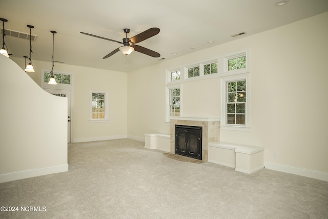 unfurnished living room with light carpet, visible vents, baseboards, and a tiled fireplace