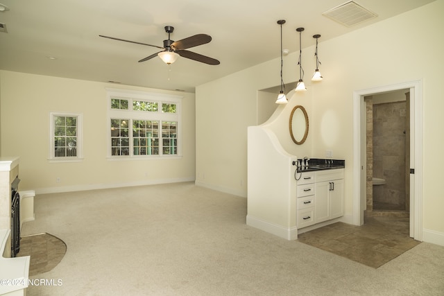 unfurnished living room with light carpet, ceiling fan, visible vents, and baseboards