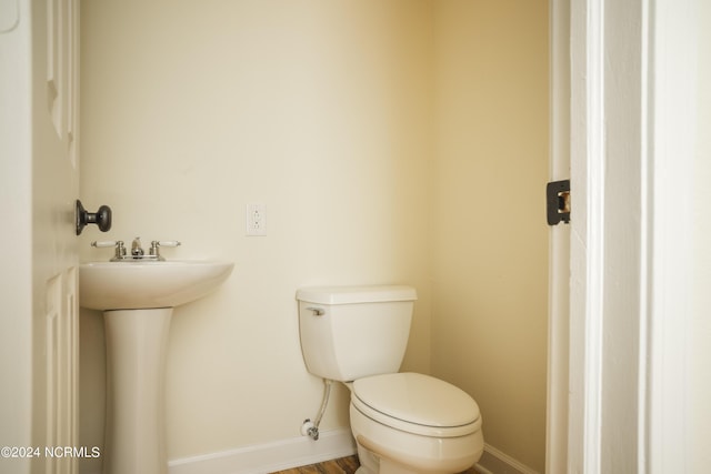 bathroom with baseboards and toilet